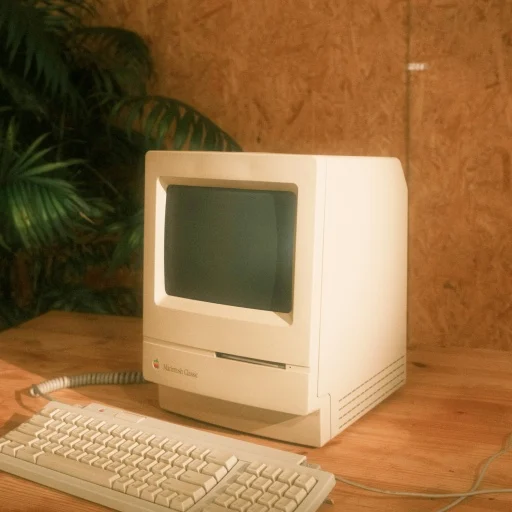 A vintage Macintosh computer on a wooden desk